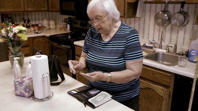 Older woman looking through her wallet